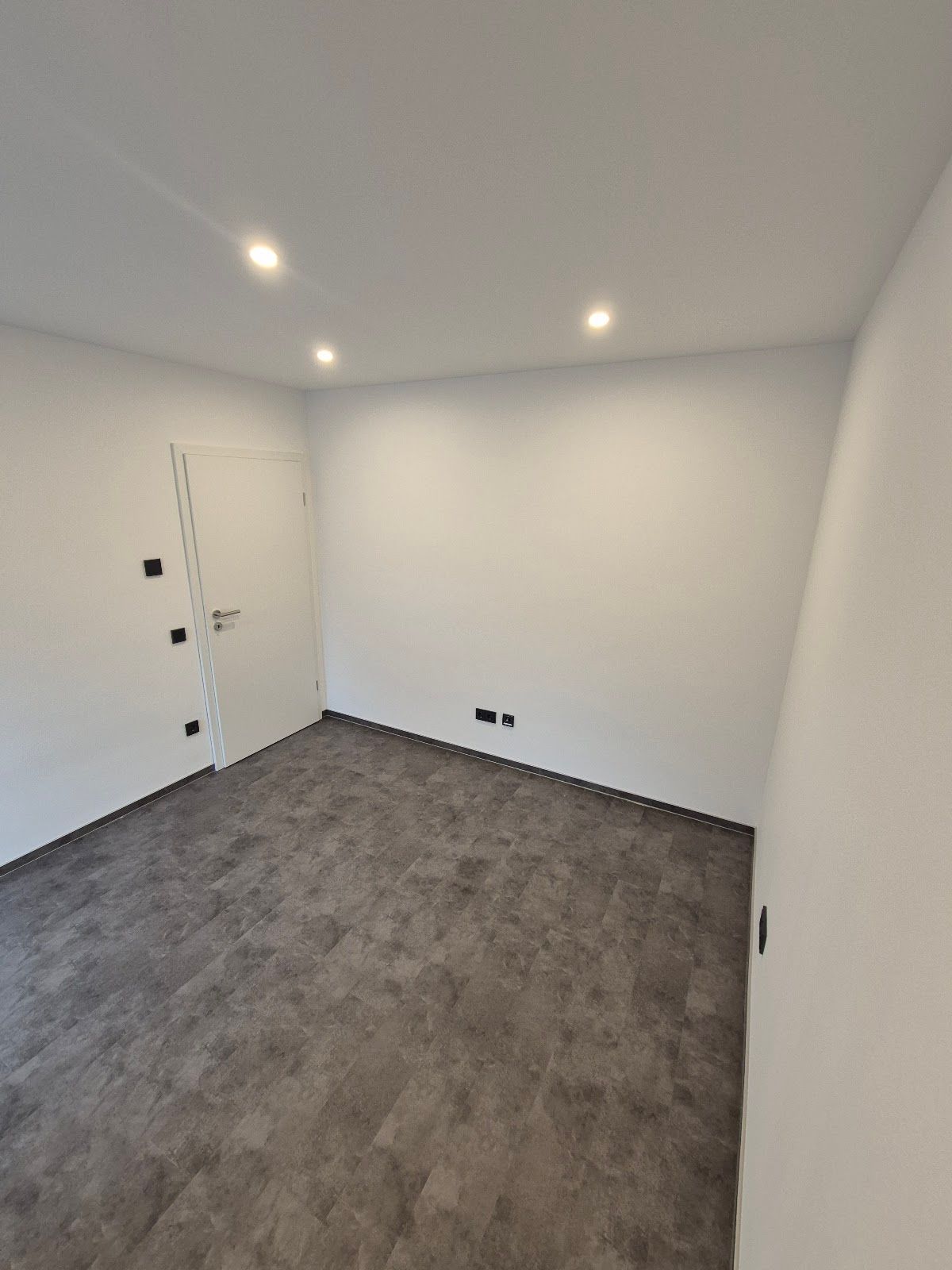 Renovierter Raum mit grauem Boden und LED-Spots